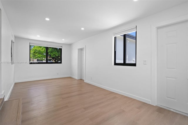 spare room with recessed lighting, baseboards, and light wood finished floors