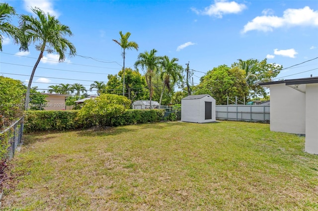 view of yard with a storage unit, a fenced backyard, and an outdoor structure