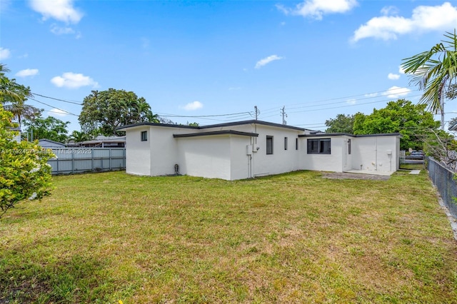 back of property featuring a fenced backyard, stucco siding, and a yard