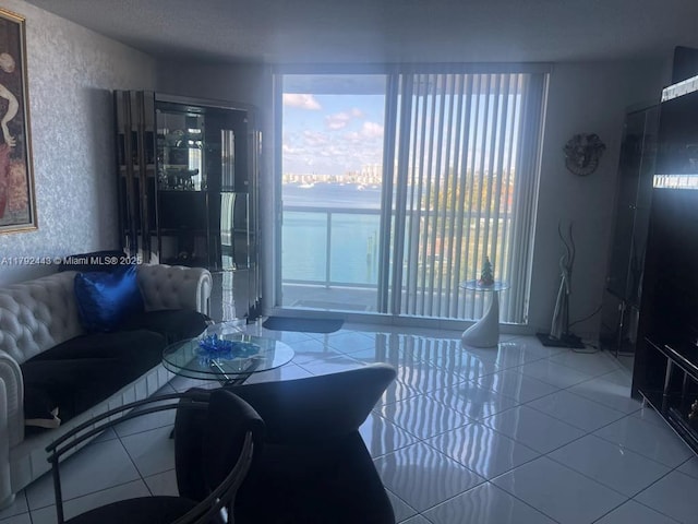 2841 NE 163rd St Unit 407, North Miami Beach, FL 33160 - tiled living area with a textured wall and plenty of natural light
