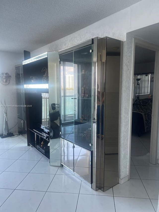 2841 NE 163rd St Unit 407, North Miami Beach, FL 33160 - hall with tile patterned flooring and a textured ceiling