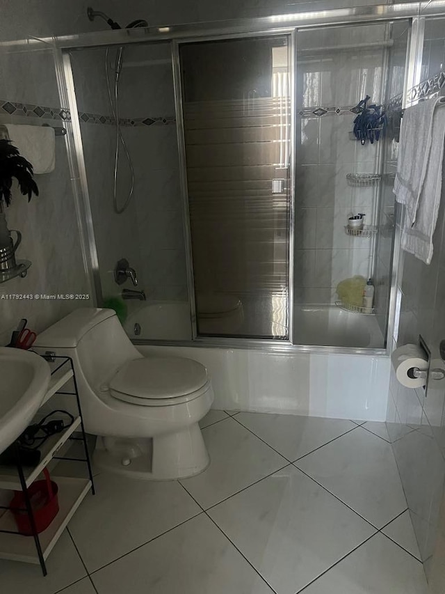 2841 NE 163rd St Unit 407, North Miami Beach, FL 33160 - bathroom featuring shower / bath combination with glass door, tile patterned flooring, and toilet