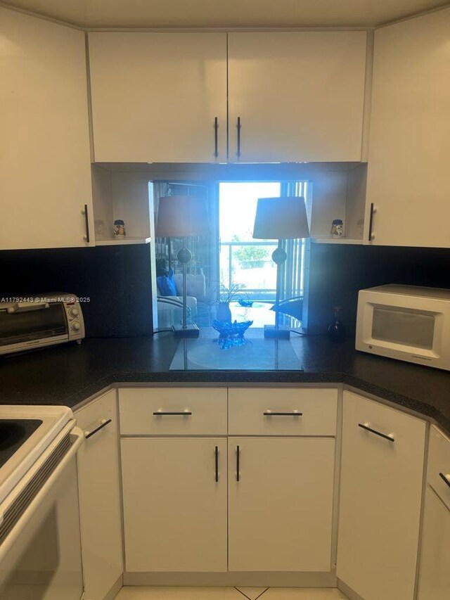 2841 NE 163rd St Unit 407, North Miami Beach, FL 33160 - kitchen with a toaster, white cabinets, open shelves, and white appliances