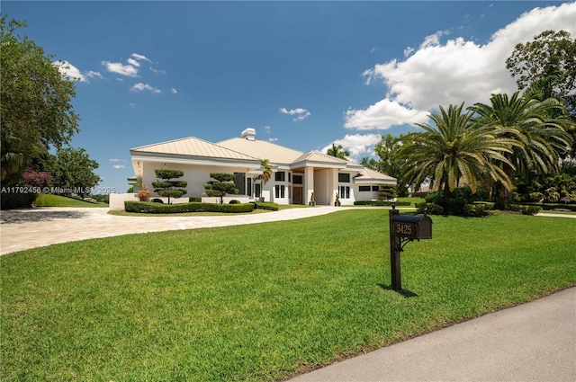 3425 Saddlebrook Ln, Weston, FL 33331 - view of front facade featuring curved driveway, a chimney, a front lawn, and metal roof