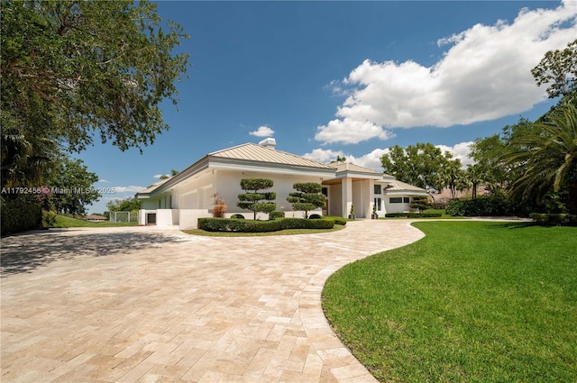 3425 Saddlebrook Ln, Weston, FL 33331 - view of front facade with a standing seam roof, metal roof, a garage, decorative driveway, and a front lawn