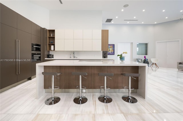3425 Saddlebrook Ln, Weston, FL 33331 - kitchen with a sink, modern cabinets, visible vents, and a high ceiling