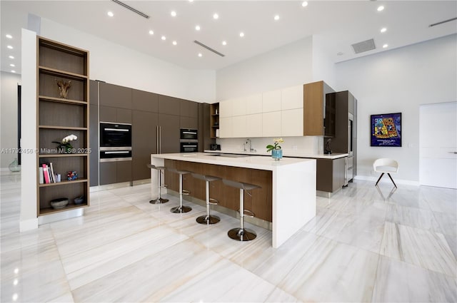 3425 Saddlebrook Ln, Weston, FL 33331 - kitchen featuring open shelves, a spacious island, a high ceiling, and modern cabinets