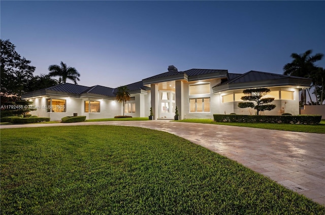 3425 Saddlebrook Ln, Weston, FL 33331 - prairie-style home featuring stucco siding, a front yard, a standing seam roof, curved driveway, and metal roof