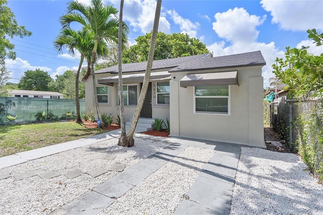 1810 NW 47th St, Miami, FL 33142 - view of front of home featuring a shingled roof, stucco siding, and fence