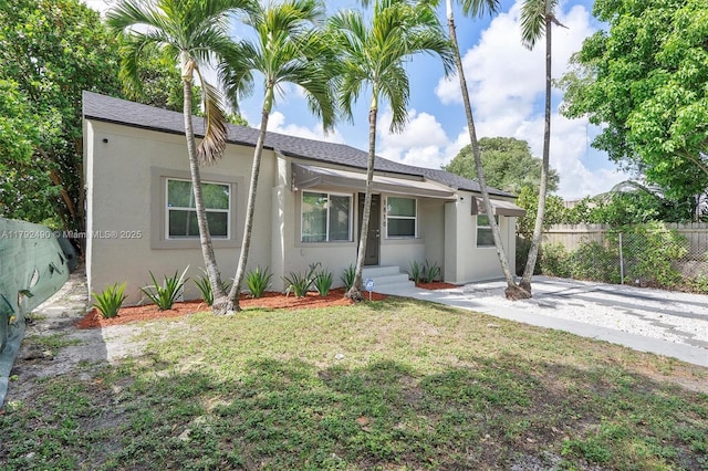 1810 NW 47th St, Miami, FL 33142 - view of front of property with stucco siding, fence, and a front lawn