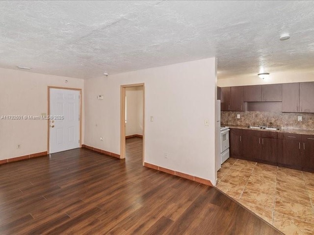 19357 NW 29th Ave, Miami Gardens, FL 33056 - unfurnished living room featuring wood finished floors, baseboards, a sink, and a textured ceiling