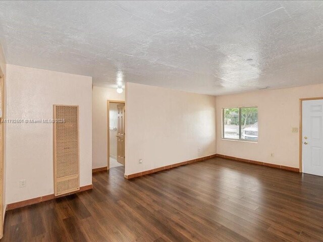 19357 NW 29th Ave, Miami Gardens, FL 33056 - spare room with a heating unit, wood finished floors, baseboards, and a textured ceiling