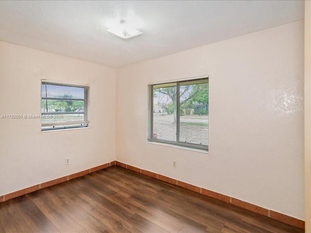 19357 NW 29th Ave, Miami Gardens, FL 33056 - empty room featuring plenty of natural light, baseboards, and dark wood finished floors