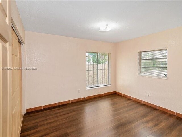 19357 NW 29th Ave, Miami Gardens, FL 33056 - unfurnished room with dark wood-type flooring, plenty of natural light, and baseboards