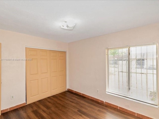19357 NW 29th Ave, Miami Gardens, FL 33056 - unfurnished bedroom featuring dark wood-type flooring, a closet, and baseboards