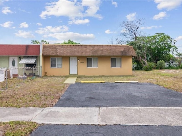 19357 NW 29th Ave, Miami Gardens, FL 33056 - multi unit property featuring mansard roof, stucco siding, uncovered parking, a front yard, and roof with shingles