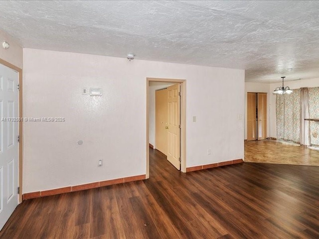 19357 NW 29th Ave, Miami Gardens, FL 33056 - spare room featuring a chandelier, wood finished floors, baseboards, and a textured ceiling