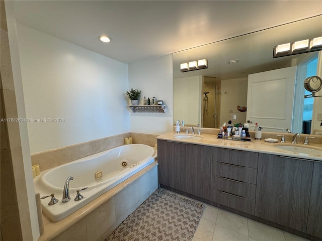 bathroom featuring double vanity, tile patterned flooring, a jetted tub, and a sink