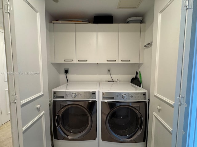 laundry area featuring washing machine and dryer and cabinet space