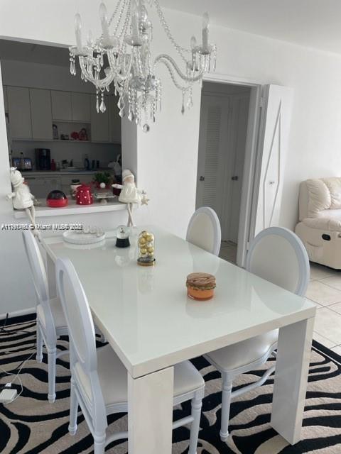 5161 Collins Ave Unit 506, Miami Beach, FL 33140 - dining area featuring light tile patterned floors and a notable chandelier