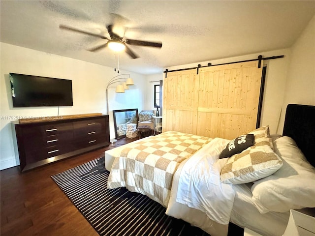 3699 Lakeview Blvd, Delray Beach, FL 33445 - bedroom featuring dark wood-type flooring, a barn door, a textured ceiling, and a ceiling fan