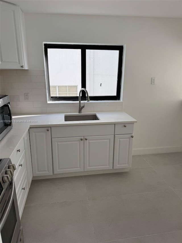 2939 Indian Creek Dr Unit 307, Miami Beach, FL 33140 - kitchen featuring white cabinets, appliances with stainless steel finishes, a healthy amount of sunlight, and a sink