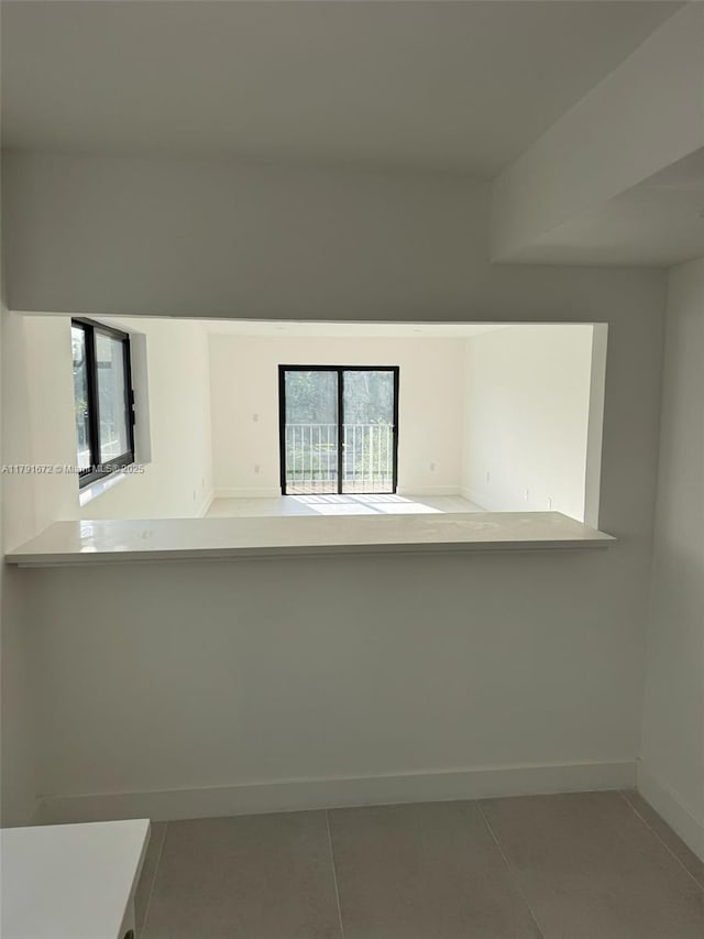 2939 Indian Creek Dr Unit 307, Miami Beach, FL 33140 - kitchen with a healthy amount of sunlight, tile patterned floors, and baseboards