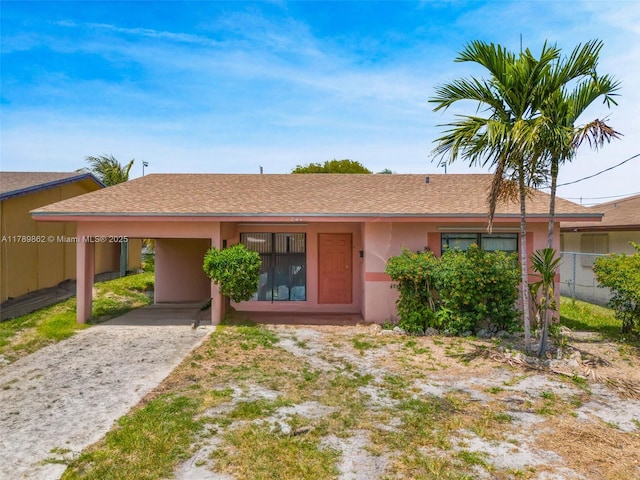 744 NW 7th St, Hallandale Beach, FL 33009 - ranch-style house with fence, a carport, stucco siding, and driveway