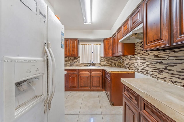 744 NW 7th St, Hallandale Beach, FL 33009 - kitchen with a sink, white refrigerator with ice dispenser, light countertops, backsplash, and under cabinet range hood