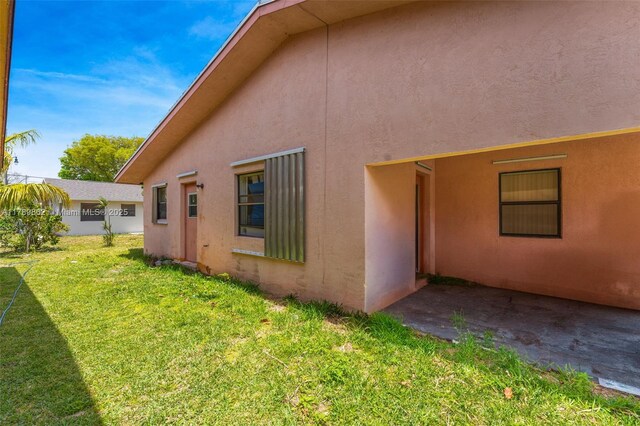 744 NW 7th St, Hallandale Beach, FL 33009 - view of property exterior with stucco siding and a yard