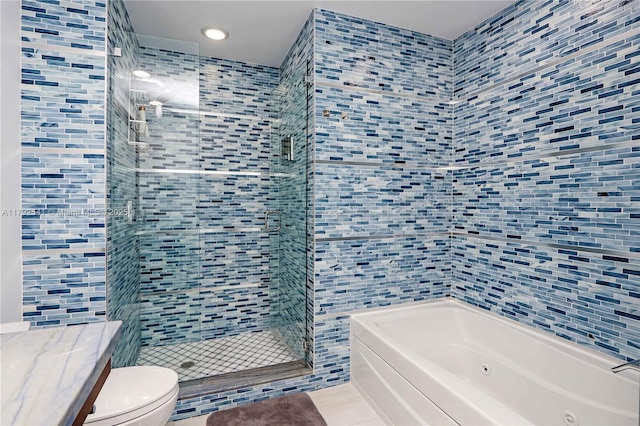 bathroom with a tub with jets, a stall shower, toilet, and tile walls