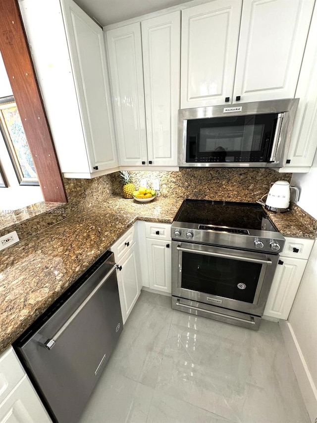 808 Brickell Key Dr Unit 3007, Miami, FL 33131 - kitchen featuring appliances with stainless steel finishes, light marble finish flooring, white cabinets, and dark stone counters
