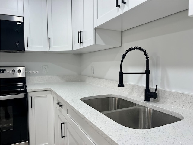 3089 E Yarmouth E Unit 3089, Boca Raton, FL 33434 - kitchen with electric range, white cabinets, and light stone countertops