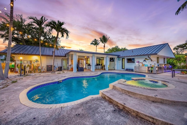 7864 SW 179th Ter, Palmetto Bay, FL 33157 - pool at dusk featuring a patio and a pool with connected hot tub