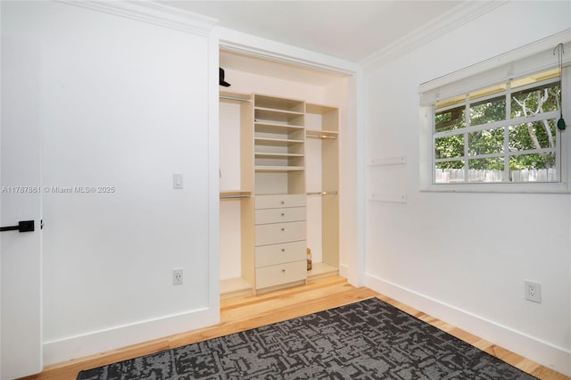 7864 SW 179th Ter, Palmetto Bay, FL 33157 - unfurnished bedroom with crown molding, baseboards, wood finished floors, and a walk in closet