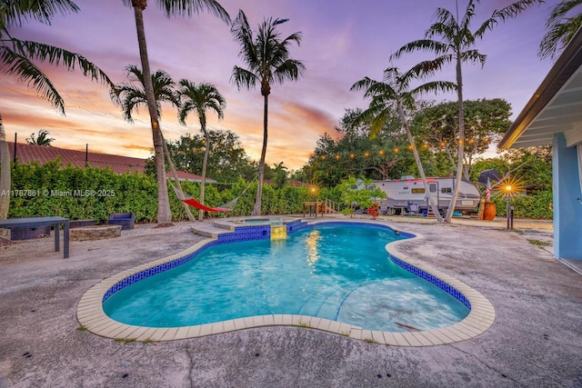 7864 SW 179th Ter, Palmetto Bay, FL 33157 - pool at dusk featuring a patio area and a pool with connected hot tub