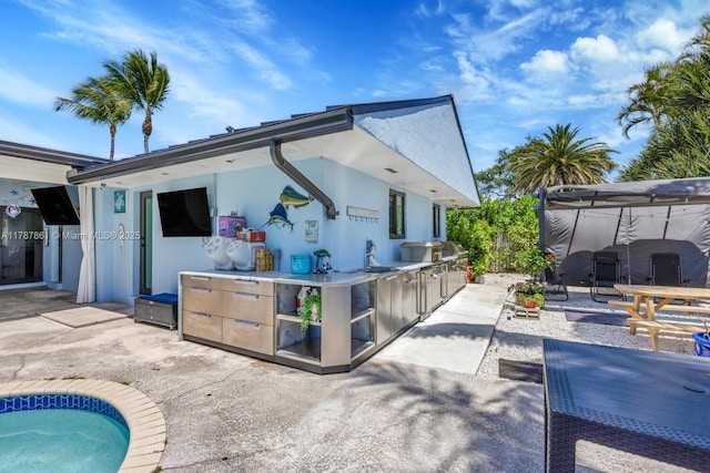 7864 SW 179th Ter, Palmetto Bay, FL 33157 - rear view of house with an outdoor kitchen, a patio area, and stucco siding
