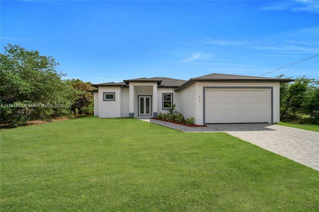 516 Millcreek St, Lehigh Acres, FL 33974 - prairie-style house with french doors, decorative driveway, a front lawn, an attached garage, and stucco siding