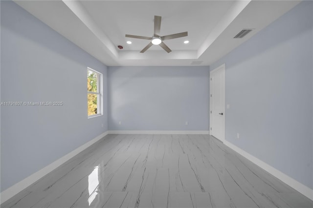 516 Millcreek St, Lehigh Acres, FL 33974 - spare room with a ceiling fan, a tray ceiling, visible vents, and baseboards