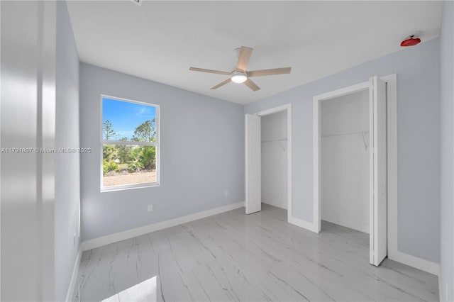 516 Millcreek St, Lehigh Acres, FL 33974 - unfurnished bedroom featuring baseboards, marble finish floor, ceiling fan, and two closets