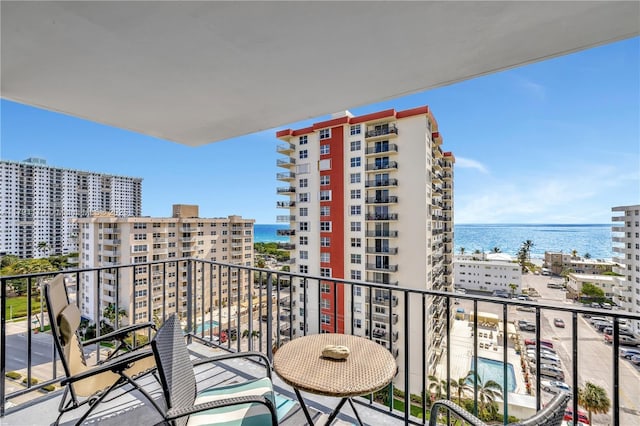balcony featuring a water view and a city view