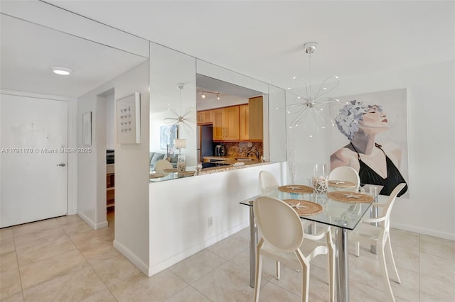 dining area featuring baseboards, an inviting chandelier, and light tile patterned floors