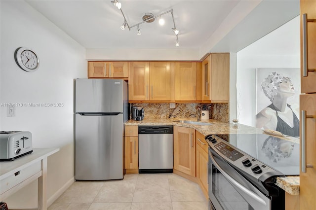 kitchen with appliances with stainless steel finishes, tasteful backsplash, a sink, a toaster, and light tile patterned flooring