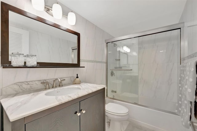 full bathroom featuring toilet, enclosed tub / shower combo, marble finish floor, and vanity