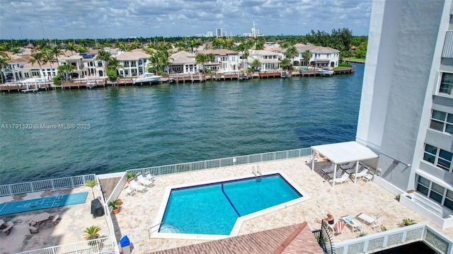 community pool featuring a residential view, a patio, and a water view