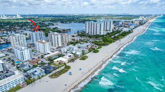 birds eye view of property featuring a water view, a view of the beach, and a view of city