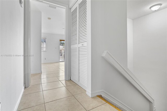 330 SW 2nd Ave Unit 3, Hallandale Beach, FL 33009 - hallway with baseboards, light tile patterned flooring, and an upstairs landing