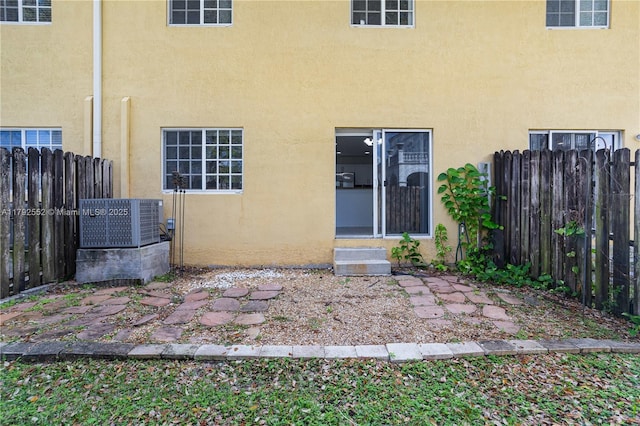 330 SW 2nd Ave Unit 3, Hallandale Beach, FL 33009 - rear view of property featuring entry steps, fence, stucco siding, and central AC