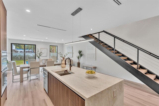 1389 SW 22nd Ter, Miami, FL 33145 - kitchen featuring a kitchen island with sink, modern cabinets, a sink, open floor plan, and light wood-style floors
