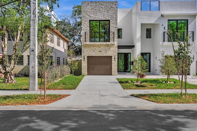 1389 SW 22nd Ter, Miami, FL 33145 - contemporary house with a garage, a balcony, concrete driveway, stone siding, and stucco siding